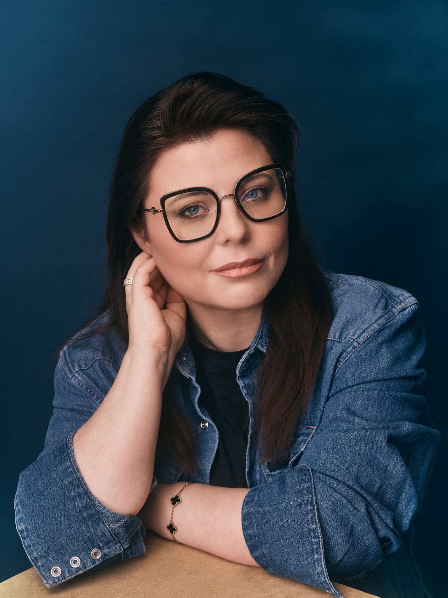 Portrait de Laurence, fondatrice de New Sight Media — fond bleu profond, regard direct