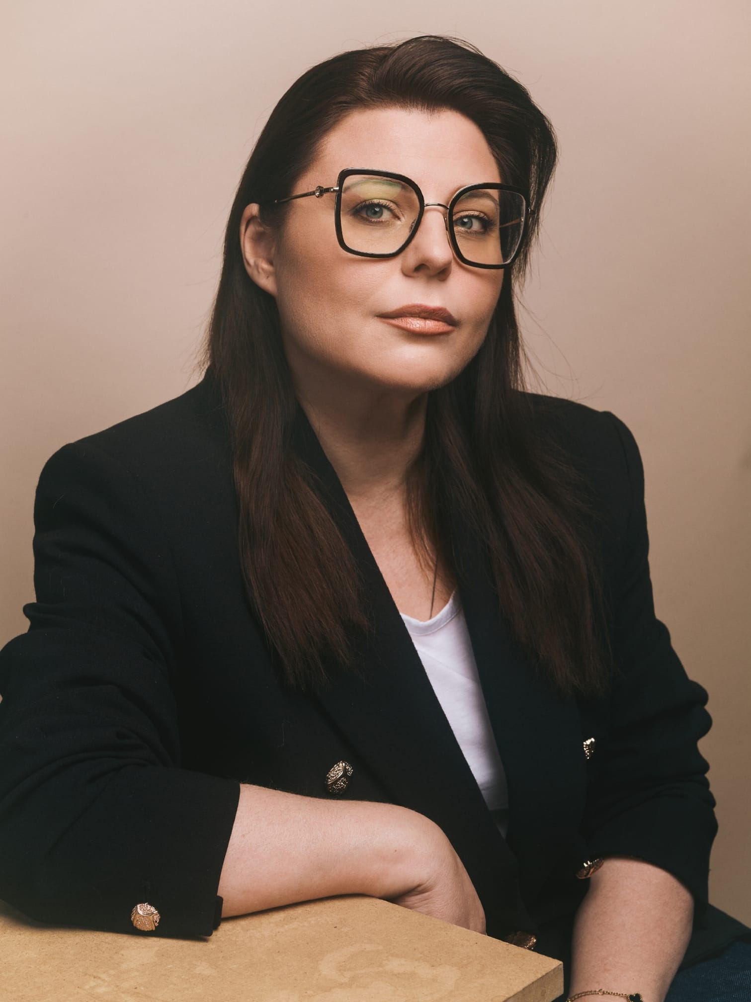 Laurence — journaliste et fondatrice de New Sight Media, portrait en veste noire sur fond crème