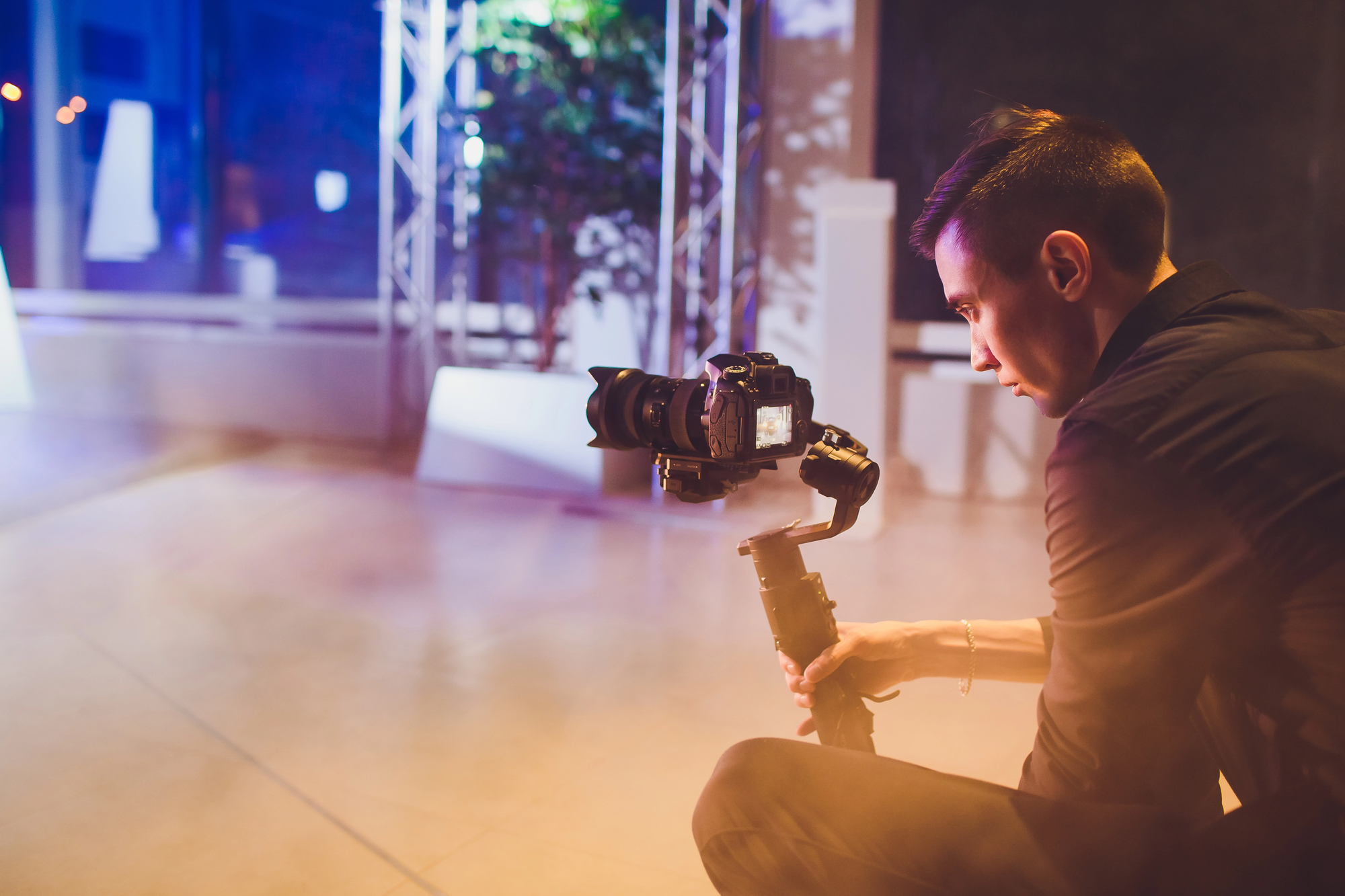 Cameraman avec gimbal lors d'un tournage événementiel — lumières chaudes, ambiance nocturne